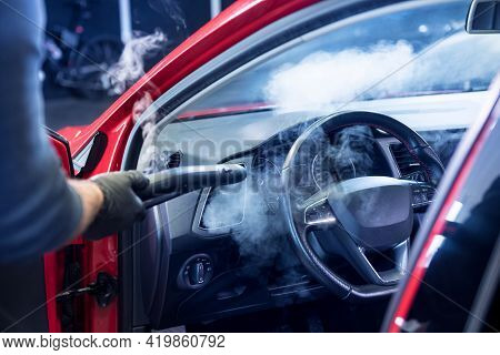 Car Service Worker Cleans Interiror With Steam Cleaner