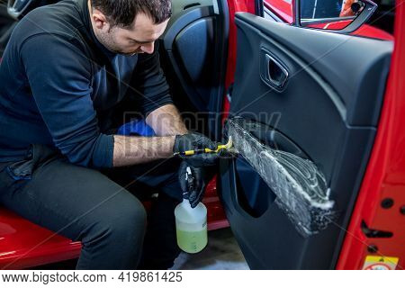 Car Service Worker Cleans Interiror With Special Brush