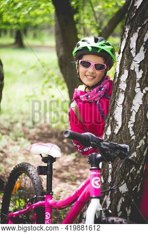 Konstantinovka, Ukraine - May 08, 2021: Little Girl In Pink Clothes Posing With A Pink Bike.