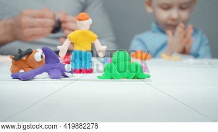 Dad And Son Sculpting Animals From Plasticine