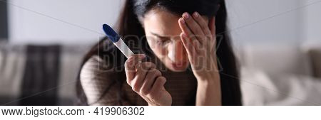 Sad Woman Sitting On Couch And Holding Pregnancy Test Closeup