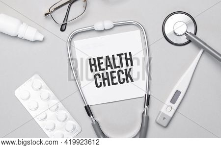 In The Notebook Is The Text Health Check, Stethoscope, Pills, And Glasses.