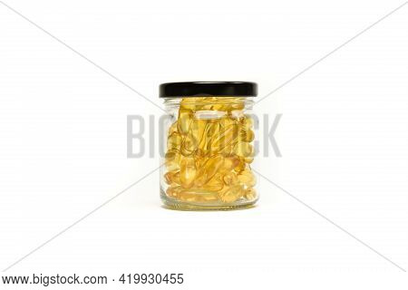 Close Up Of Gold Fish Oil In Jar Glass Isolated For Good Health On White Background View. Supplement