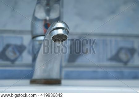 Dripping Old Faucet In Bathroom. Water Dripping From A Tap Into White Sink, Close-up Bottomview. Rec