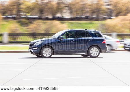 Blue Offroad Car Mercedes-benz M-class Rides In The City Street. Side View Of Fast Moving Suv Car On