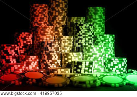 Stack Of Poker Chips On A Green Gaming Poker Table At The Casino. Poker Game Concept. Chips For Poke