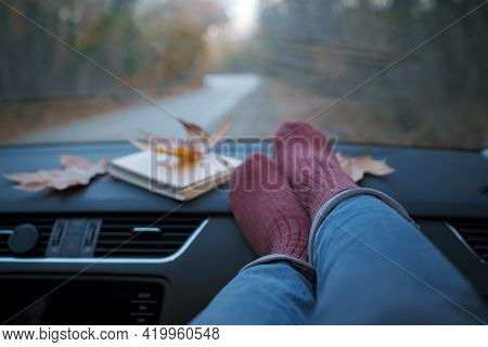 Woman Feet In Warm Socks On Car Dashboard.