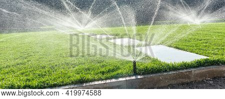 Garden Irrigation System Lawn. Automatic Lawn Sprinkler Watering Green Grass. Selective Focus.
