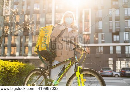 Kiev, Ukraine - April 28, 2021: Glovo Bike Courier On The Street. Delivery Of Glovo Delivery Service