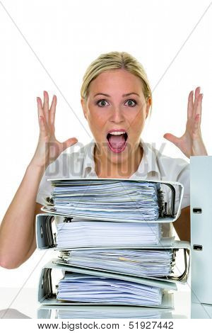 a young woman desperately in office between many file folders and crumpled papier.symbolfoto for stress, burnout and overwork.