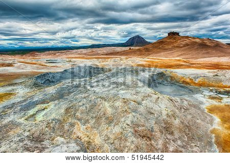 Mudpots in the geothermal area Hverir, Iceland. The area around the boiling mud is multicolored and cracked. HDR image