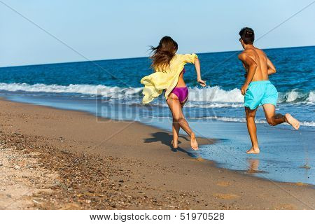 Teen Couple Chasing On Beach.