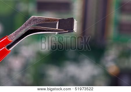 SMD Chip Is Kept With A Pair Of Tweezers