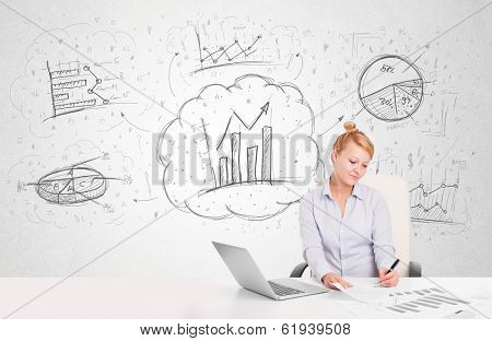 Business woman sitting at white table with hand drawn graph charts