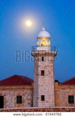 Ciutadella Menorca Punta Nati lighthouse with moon shining in sky