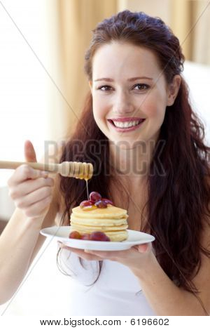 Lächelnde Frau Essen Palatschinken mit Obst und Honig