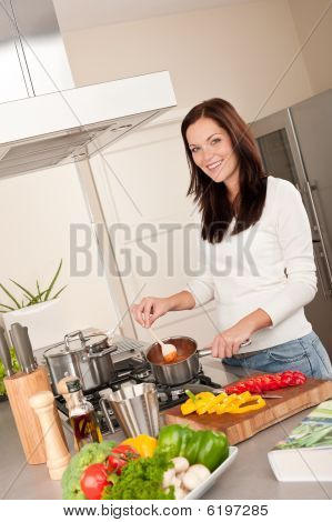 junge Frau Tomatensoße in der Küche kochen