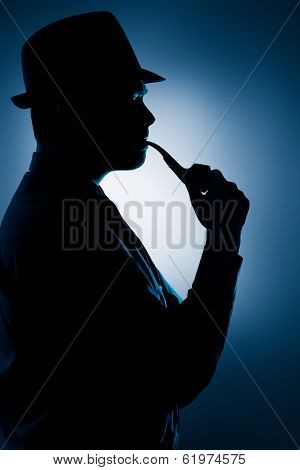 Silhouette of Man Smoking Pipe on a Spotlight Background