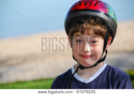 Portrait of a cute little boy in bicycle helmet making silly faces