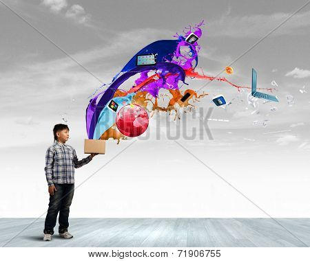 Young boy splashing colorful paint from bucket