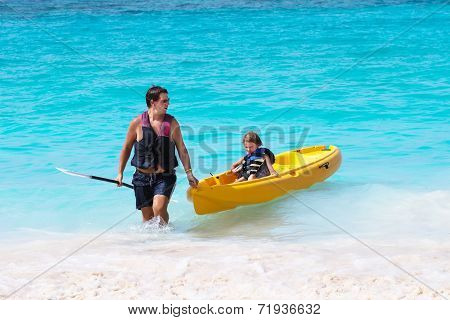 Father And Son Enjoying A Kayak Ride On A Troical Beach