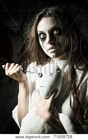 Horror Style Shot: Scary Monster Girl With Moppet Doll And Needle In Hands