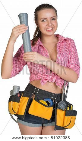 Woman in tool belt holding fitting pipe