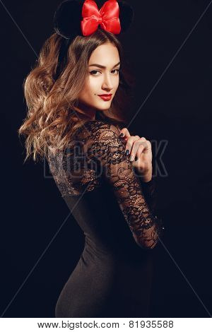 Portrait of a beautiful model with a red bow on a dark background.