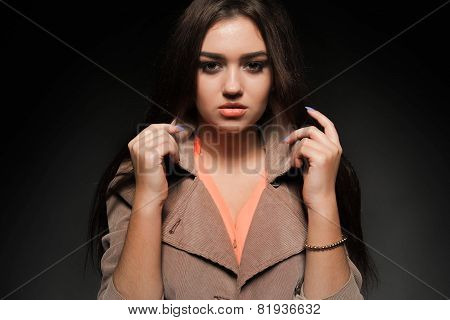 Beautiful brunette with long hair on a dark background