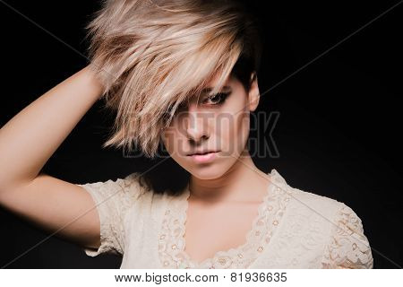 Blonde girl with a short stylish haircut on a dark background