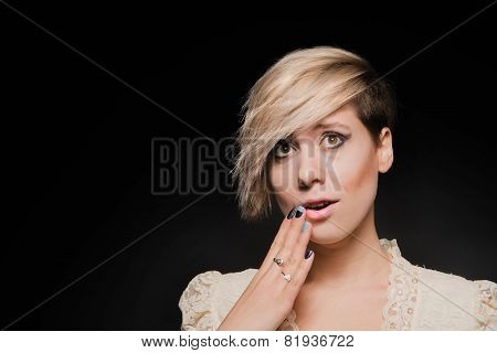Blonde girl with a short stylish haircut on a dark background