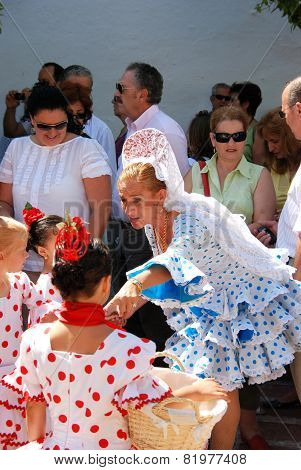 Spanish woman and girls in traditional dress.