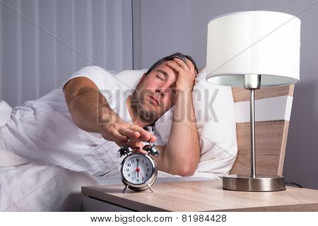 Man Snoozing Alarm Clock