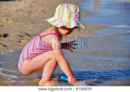 Menina bonito na beira-mar