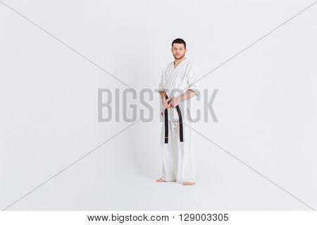 Full length portrait of a man in kimono standing isolated on a white background