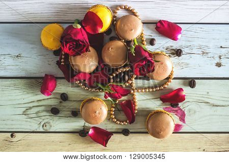 Macaruns with roses, necklace and coffee on flat