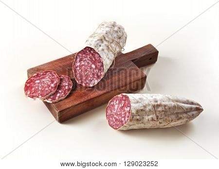 Two pieces of Salami and slices on Cutting board