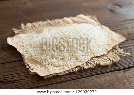 Pile of Basmati rice on a wooden table close up
