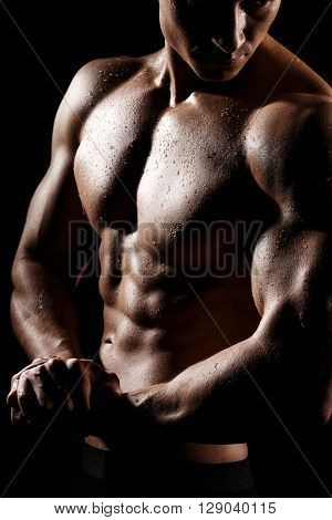 Muscular And Fit Young Bodybuilder Fitness Male Model Posing Over Black Background. Perfect Fitness