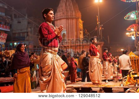 VARANASI, INDIA - JANUARY 3, 2013: Young indian priests Brahmins pray during the night ritual dedicated to the River Ganges on January 3, 2013. Varanasi urban agglomeration had a population of 1435113