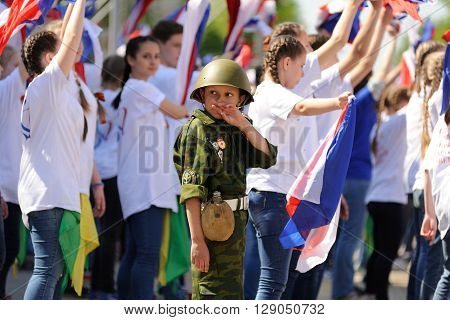 Orel Russia - May 9 2016: Celebration of 71th anniversary of the Victory Day (WWII). Boy in military uniform and helmet and young people dancing horizontal