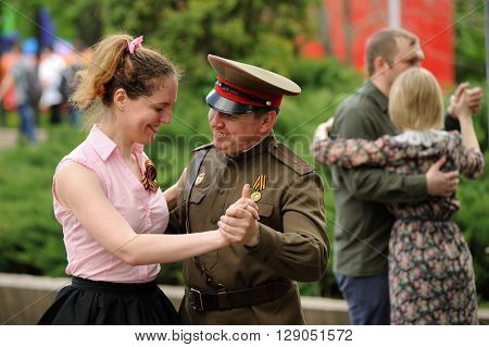 Orel Russia - May 9 2016: Celebration of 71th anniversary of the Victory Day (WWII). Man in military uniform dancing with woman in park horizontal