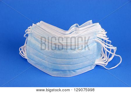 single medical ear-loop mask on blue background
