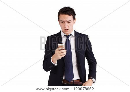 A young Caucasian business man is frowning holding a moble phone.