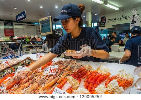 Sydney Australia - November 11 2014: Vendor preparing seafood for a buyer in Famous Sydney Fish Market Sydney New South Wales Australia.