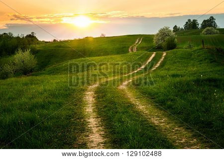 The Sun set over the dirt winding road. May 2016 Masuria Poland.