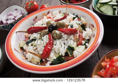 Shopska salad with cheese, fresh vegetables, olives and chili pepper