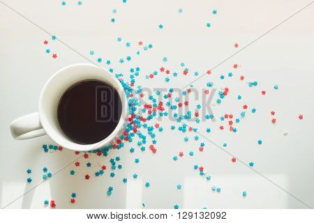 sprinkles stars around a cup of coffee