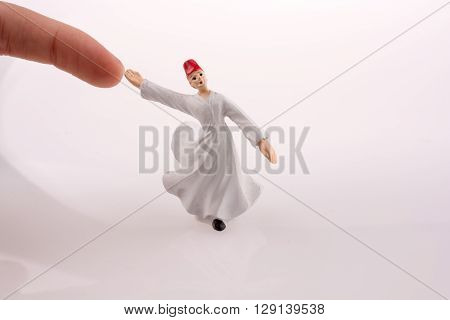 Hand holding a Sufi Derviş on a white background