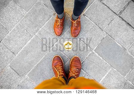 Couple standing near the small crown symbol on the sidewalk in Bratislava city in Slovakia